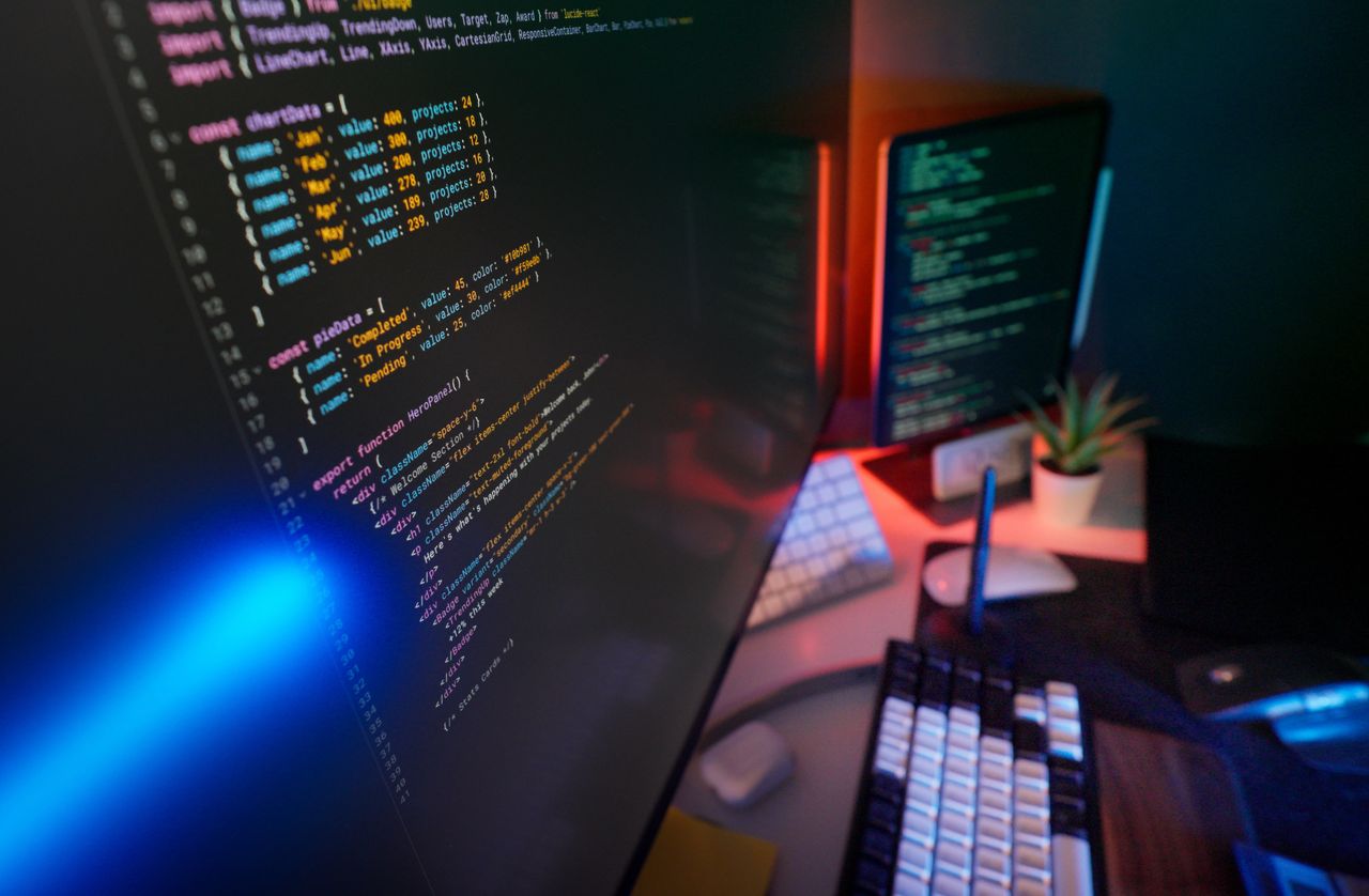 gallery-01 A vibrant workspace featuring colorful code on computer monitors, ideal for developers.